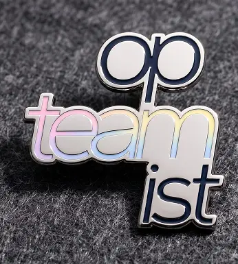 Pin esmaltado con la palabra Opteamist dividida en tres líneas apiladas, sobre tela gris