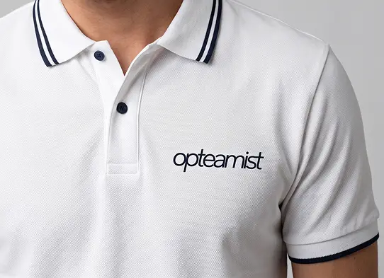 Primer plano de un polo blanco con el wordmark de Opteamist bordado sobre el pecho